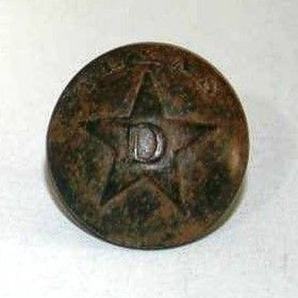 The button after cleaning. “Texas” is above the top of the star. The “D” stands for Dragoons, another name for cavalrymen. The back gives the maker as: “SCOVILL* WATERBURY”. This button is very rare.