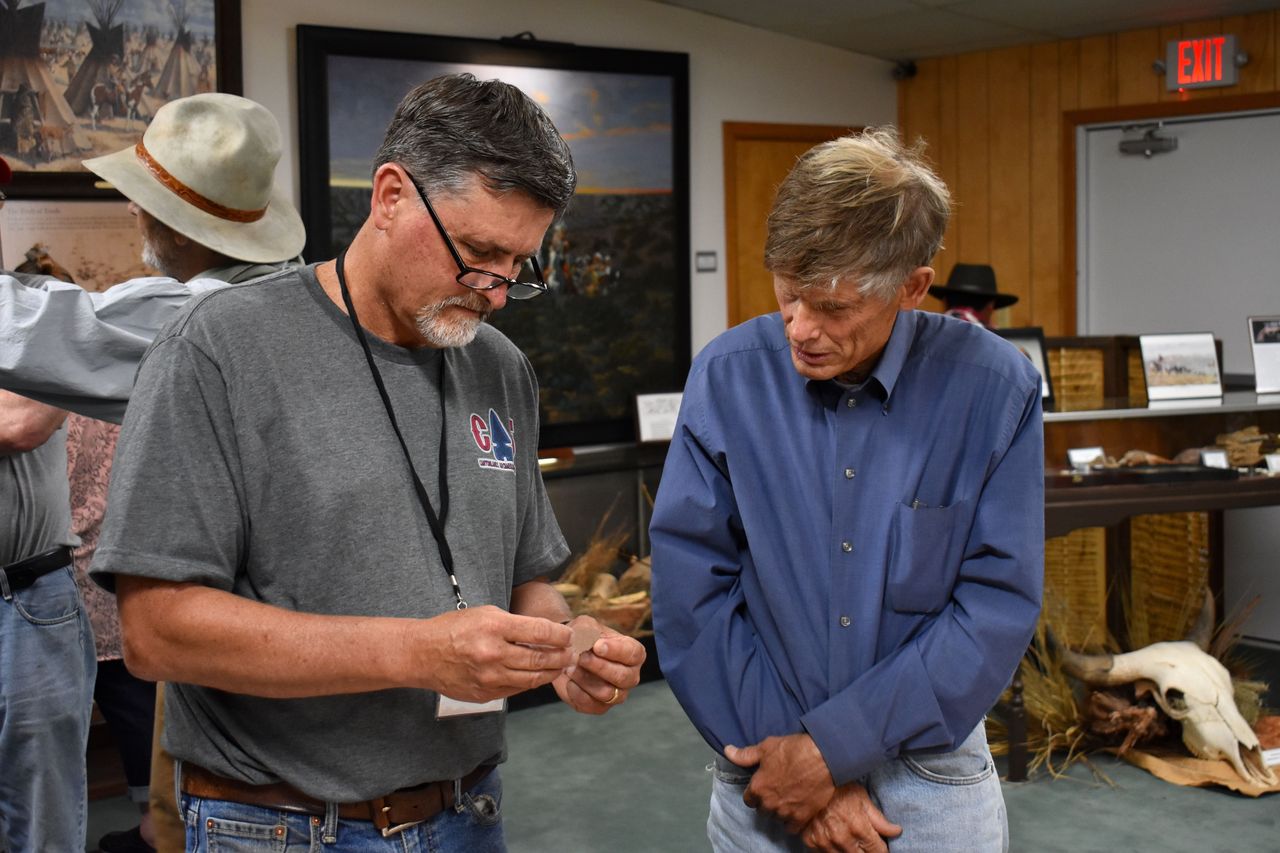 Archaeologist Rick Day examines artifacts brought by visitors