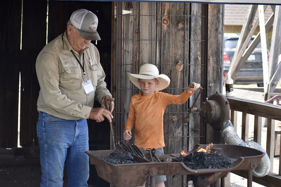 Cotton Elliot draws a young crowd with his outdoor blacksmith demonstration.