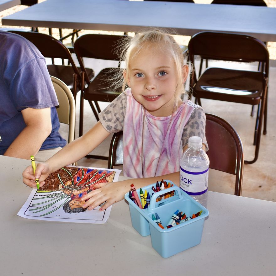 Young girl coloring a picture of a Native American.